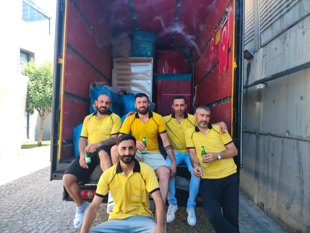 Fırat Lojistik ekibi yüklenmiş nakliye kamyonunun önünde